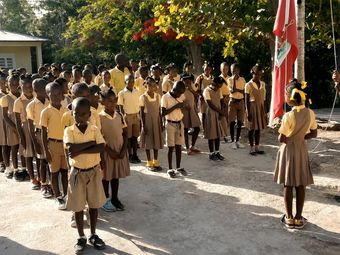A large gathering of students and staff outdoors at an HEF school in the mountains of southern Haiti