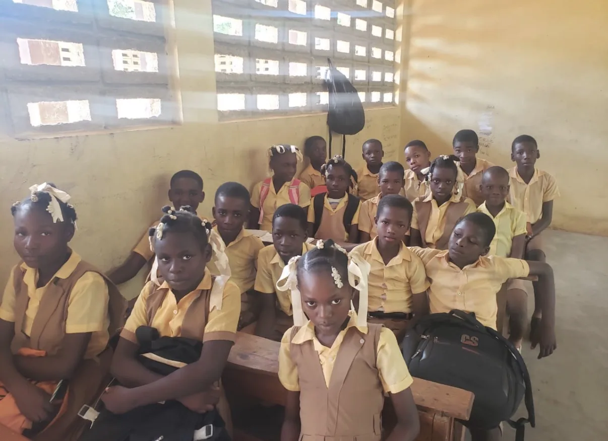 Students in brown and yellow uniforms sit at their desks in an HEF classroom